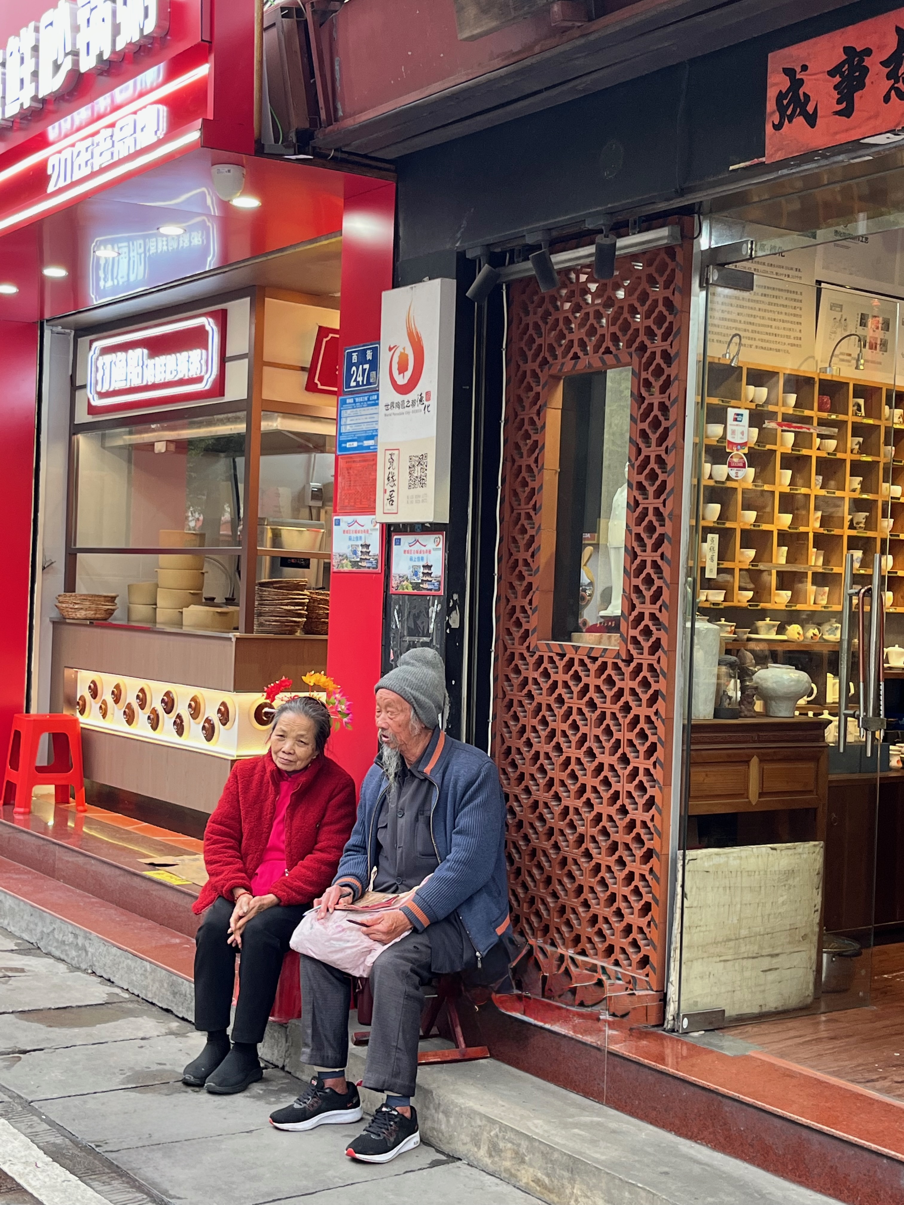 Couple âgé assis devant des boutiques traditionnelles de la rue de l'Ouest à Quanzhou