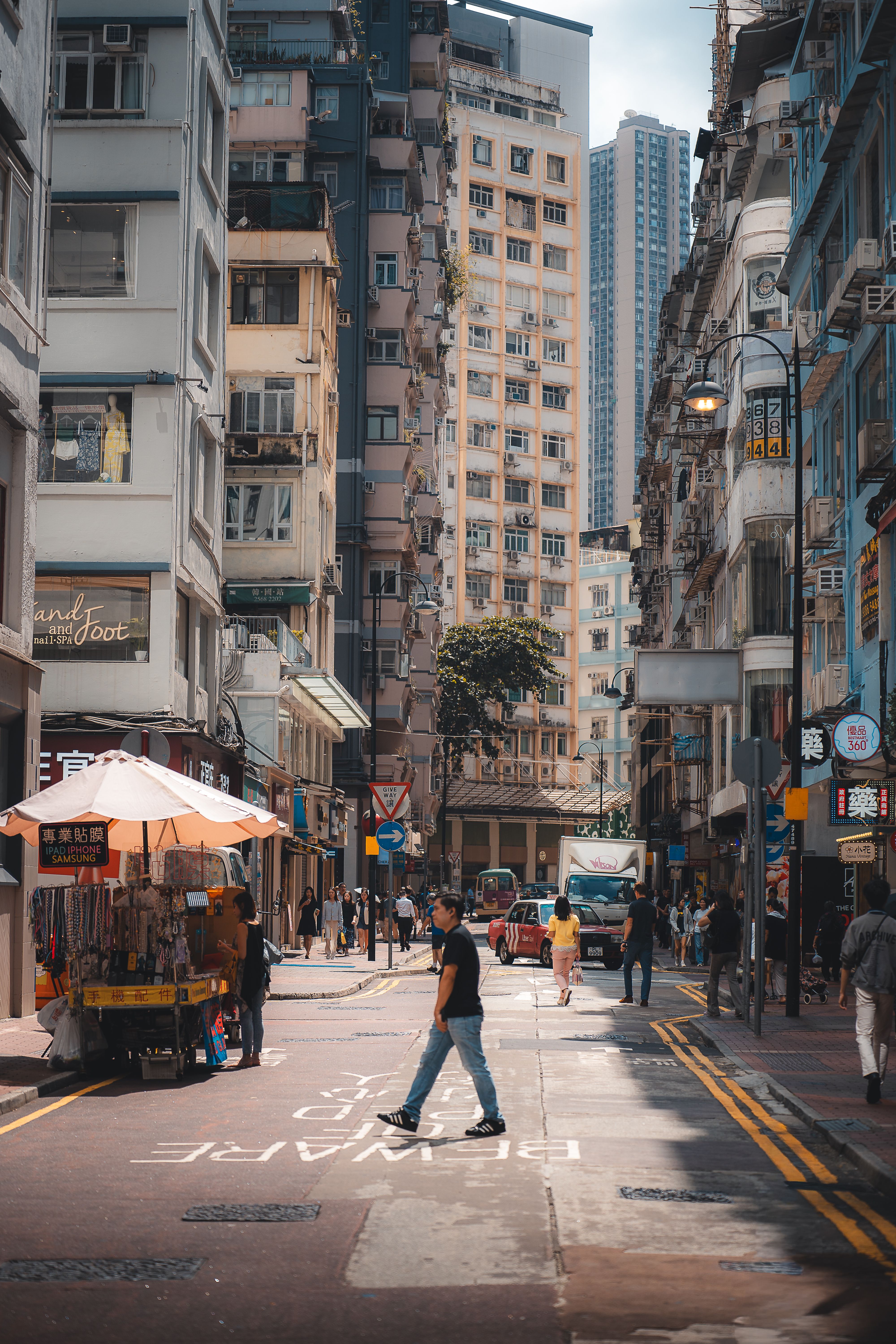 Rue animée de Hong Kong, passants, étal de rue et immeubles résidentiels