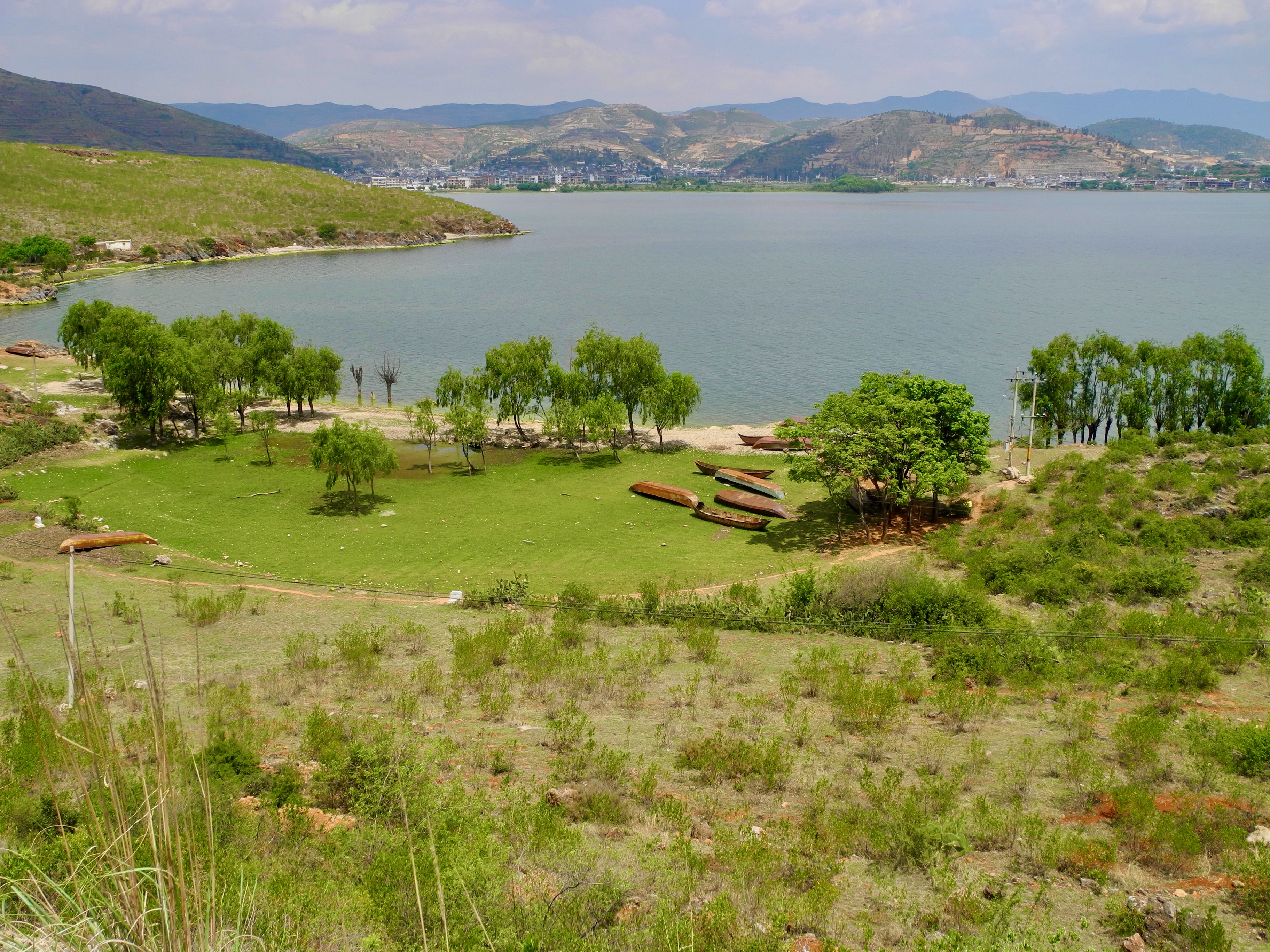 Le lac Erhai à Dali, barques traditionnelles et collines en terrasses en arrière-plan